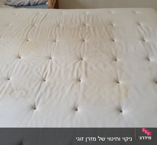 מזרן עם כתמים כהים ולחיצות כפתורים